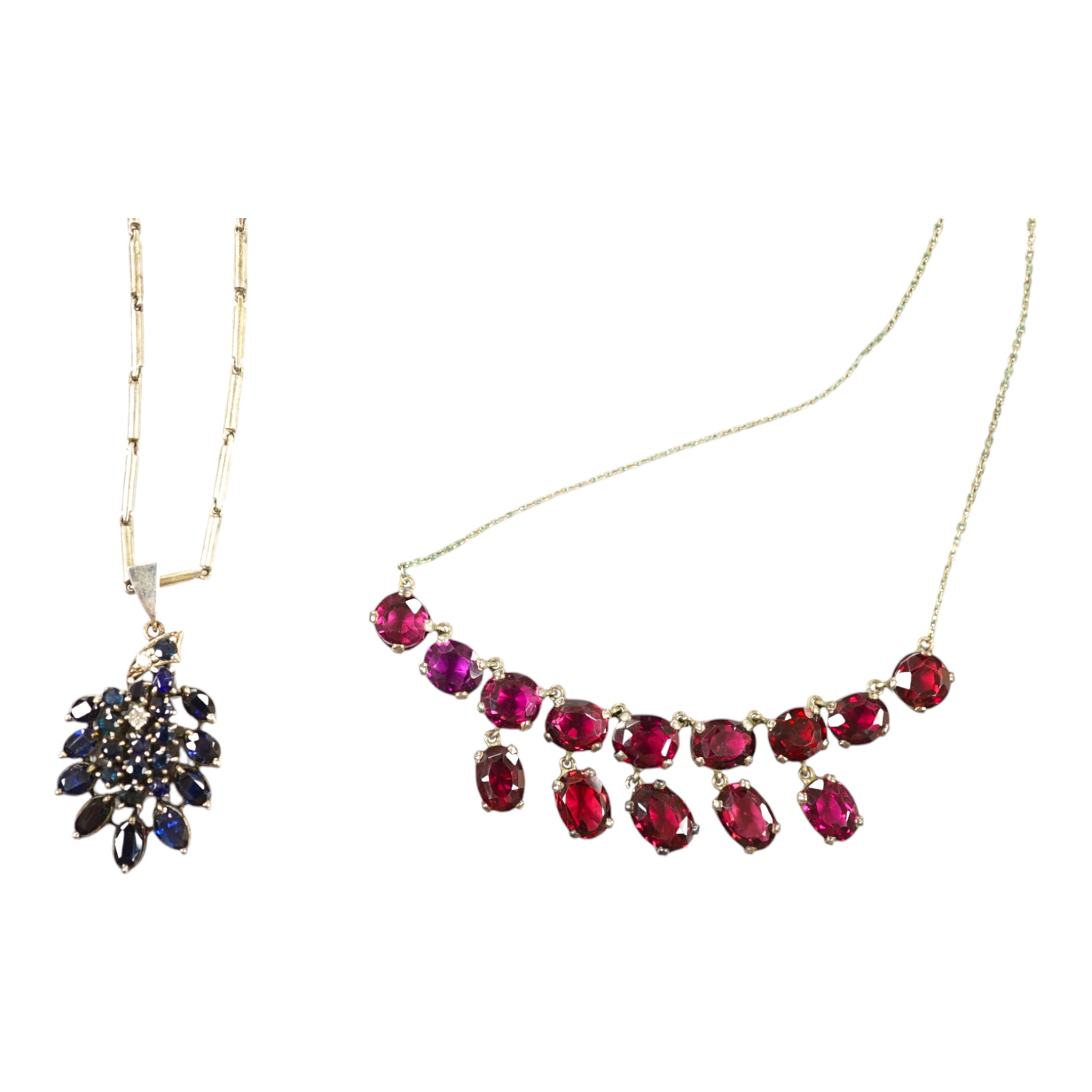 A white metal and garnet cluster set drop necklace, overall 48cm, together with a white metal, sapphire? and diamond cluster set pendant, on a white metal chain. Condition - fair